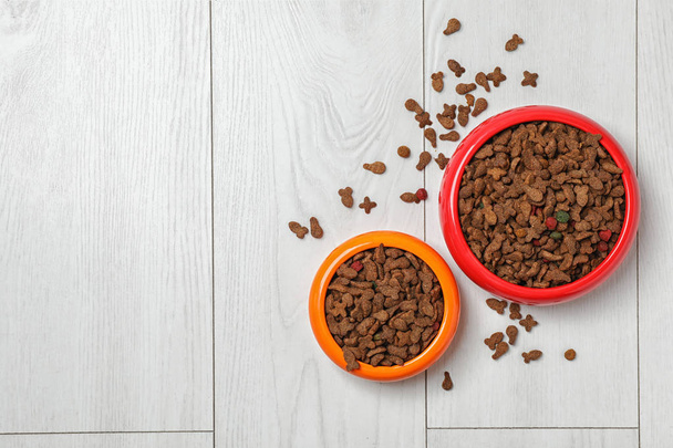 Bowls with food for cat and dog on wooden background. Pet care - Foto, Bild