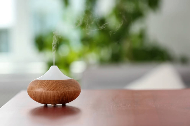 Aroma oil diffuser lamp on table against blurred background - Foto, Imagen