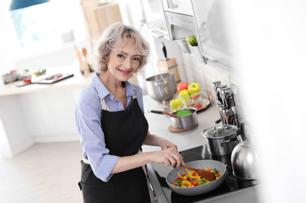 Professional female chef cooking vegetables in kitchen - Foto, Imagem