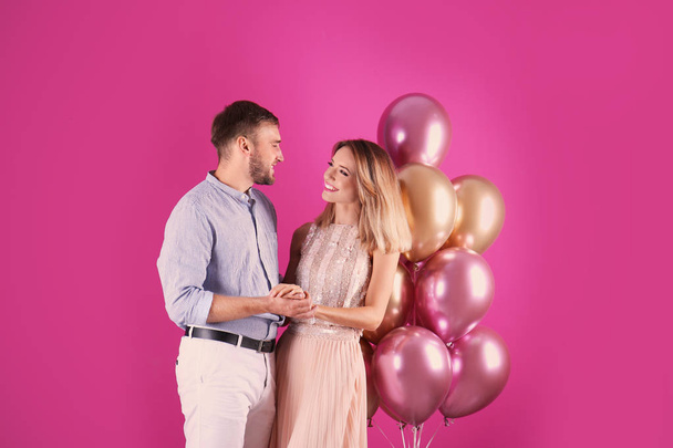 Young couple with air balloons on color background - Foto, immagini