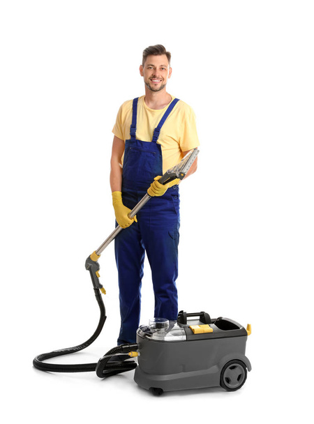 Male janitor with carpet cleaner on white background - Fotó, kép
