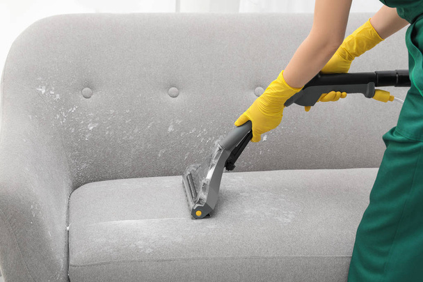 Janitor removing dirt from sofa with upholstery cleaner, closeup - Fotografie, Obrázek