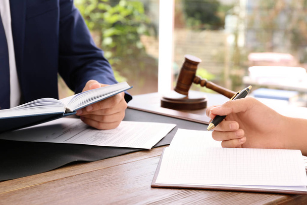 Právník pracující s klientem u stolu v kanceláři, zaměření na ruce - Fotografie, Obrázek