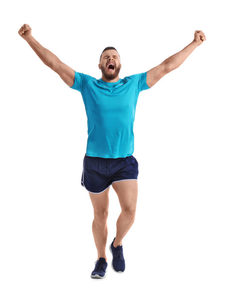 Young happy man in sportswear running on white background - Foto, Imagen