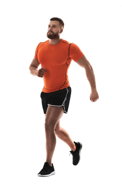 Young man in sportswear running on white background - Foto, Imagen