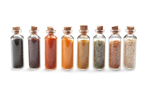 Row of small glass bottles with different spices on white background - Foto, Imagen
