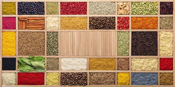 Spices and herbs in  wooden box, top view. Seasonings from all over the world for cooking food. - Photo, Image