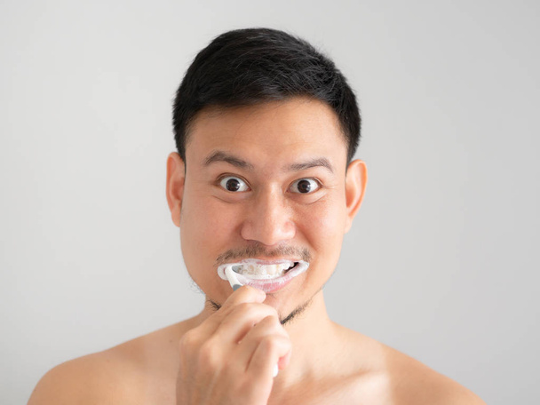 Funny face Asian man brush his teeth with foam over his face. - Photo, Image