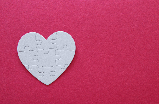 Top view image of paper white heart puzzle over pink background. Health care, donate, world heart day and world health day concept. - 写真・画像