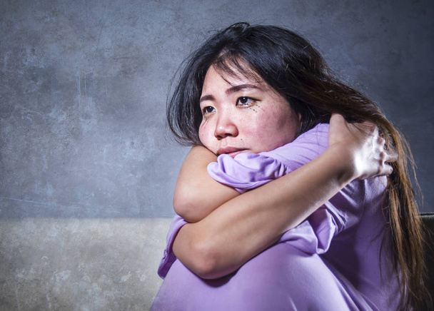 jeune femme chinoise asiatique triste et déprimée pleurant seule désespérée assise à la maison canapé ouch inquiet dans la douleur et le stress souffrir dépression et problème d'anxiété se sentir seul et impuissant
  - Photo, image