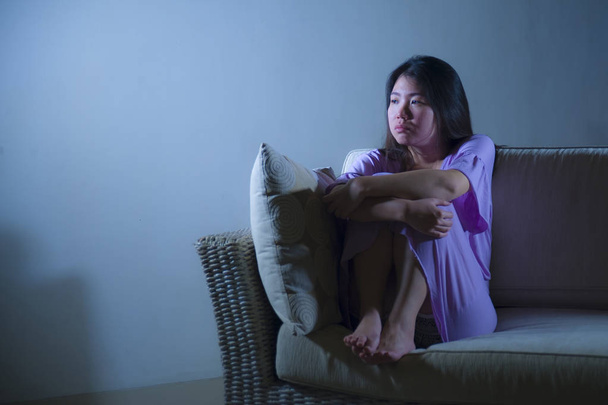young sad and depressed Asian Korean woman at home sofa couch crying desperate and helpless suffering anxiety and depression feeling pain in relationship and lonely life problem concept - Foto, immagini