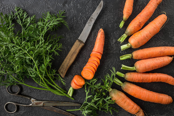 Flat lay composition with  fresh carrots on dark rustic  background.  Vegetables Vitamins Keratin. Natural organic healthy food concept. Top view - Photo, Image