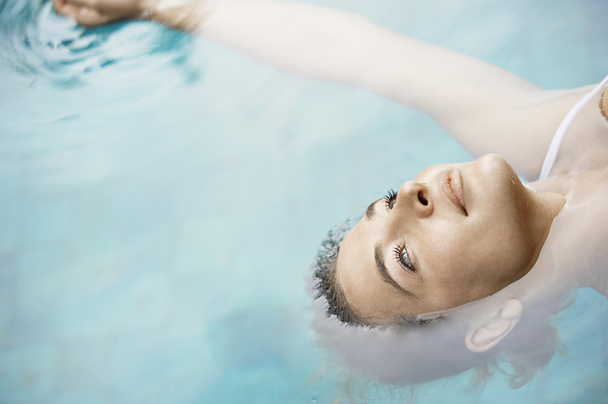 приваблива молода жінка плаває на блакитній воді
. - Фото, зображення