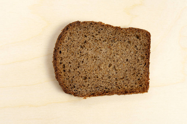 Slice of bread on a wooden background. - Photo, image