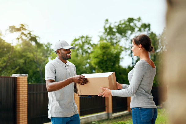 Package Delivering. Delivery Man Delivering Box To Woman - Photo, Image