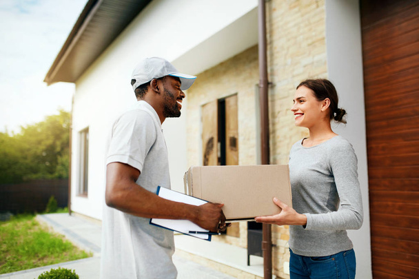 Courier Delivery. Man Delivering Package To Woman At Home - Foto, imagen