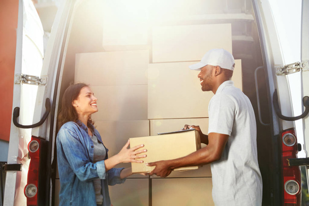 Delivery Service. Courier levering van pakket aan de vrouw in de buurt van auto - Foto, afbeelding