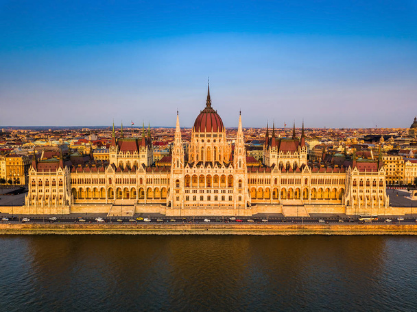 Budapest, Hungary - Aerial view of the beautiful Parliament of Hungary (Orszaghaz) at golden sunset with clear blue sky - Photo, Image