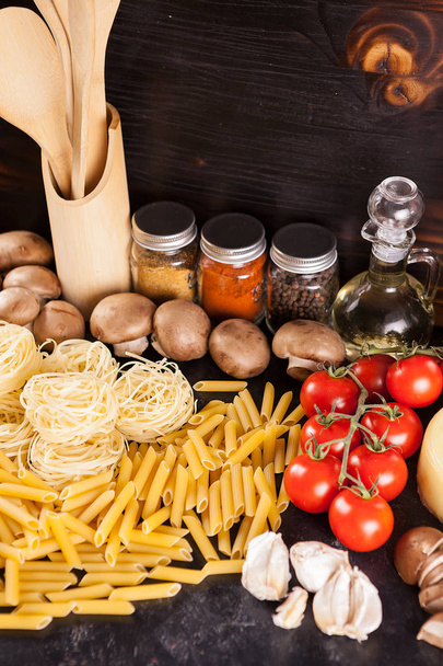 Italialaista ruokaa raa 'asta kypsentämättömästä pastasta tuoreiden vihannesten vieressä
 - Valokuva, kuva