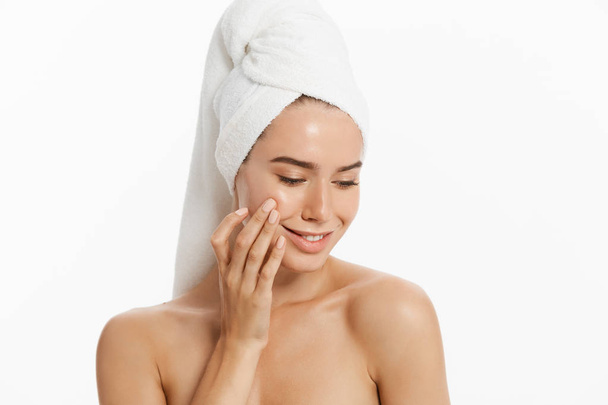 Szczęśliwa młoda dziewczyna z czystą skórą i białym ręcznikiem na głowie myje twarz - Zdjęcie, obraz