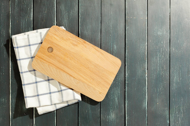 empty wooden board with tablecloth on dark desk - Foto, imagen