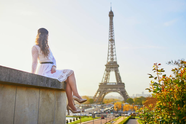 Happy young woman in white dress near the Eiffel tower in Paris, France - Фото, зображення