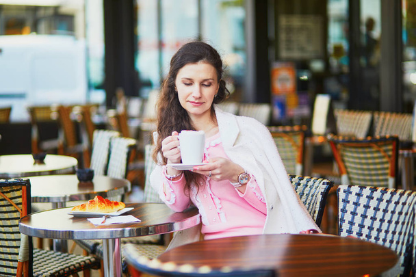 Gyönyörű fiatal nő iszik kávét szabadtéri kávézó és étterem, Párizs, Franciaország - Fotó, kép