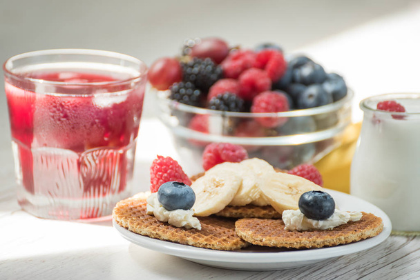 Waffles with cheese, yogurt and raspberries. A delicious wholesome breakfast on a light background. Very soft selective focus. - Foto, afbeelding