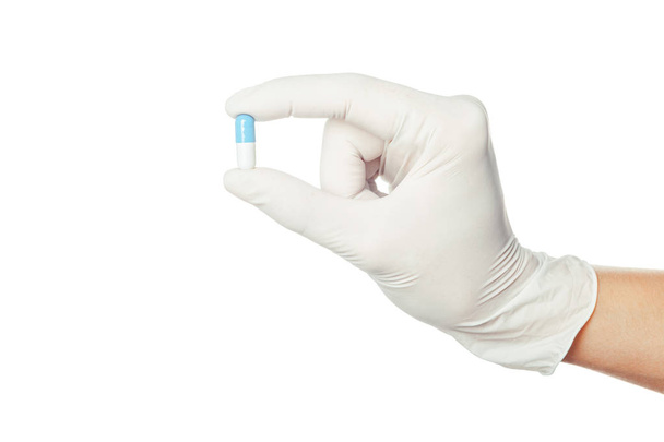dokter hand in witte gesteriliseerde chirurgische handschoen holding geneeskunde - Foto, afbeelding