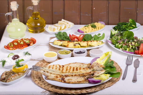 Tischdekoration mit verschiedenen Grillgerichten aus Fleisch, Fisch und Gemüse - Foto, Bild