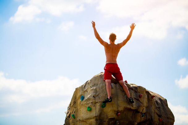 Photo from back of male climber on top of stone - Zdjęcie, obraz