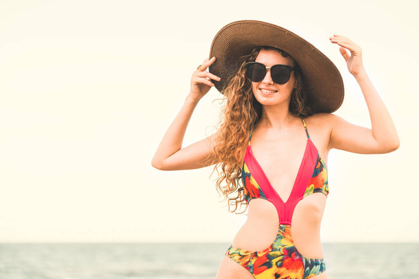 Szczęśliwa młoda kobieta na sobie strój kąpielowy o dobry czas na tropikalnej plaży latem dla podróży wakacje. - Zdjęcie, obraz