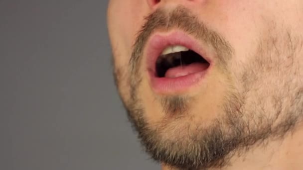 bearded man opens his mouth, sneezes, wipes his nose with his hand, side view, closeup macro  - Footage, Video
