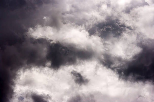 storm cloud op zonnige dag. licht in de donkere en dramatische storm-slouds. achtergrond van de storm wolken voordat een onweersbui - Foto, afbeelding