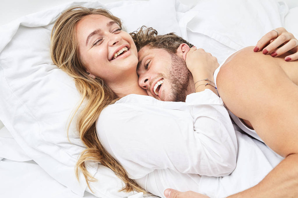 Sourire jeune couple relaxant au lit
 - Photo, image