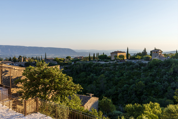 vista panorámica de casas tradicionales, vegetación verde y montañas lejanas en provence, francia
   - Foto, Imagen