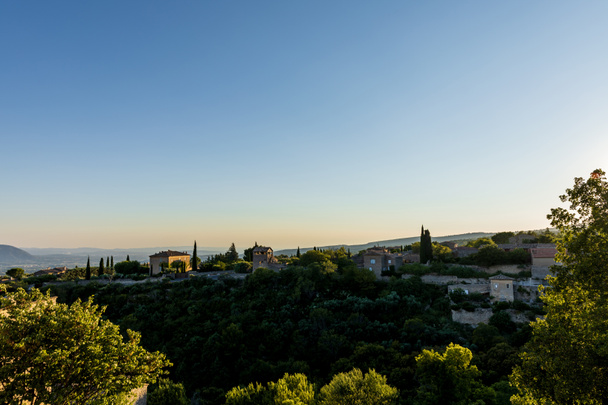 paysage tranquille avec des maisons traditionnelles confortables, végétation verte et montagnes lointaines en provence, france
   - Photo, image