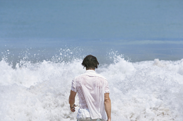 pohled zezadu na mladého muže do divoký oceán. - Fotografie, Obrázek