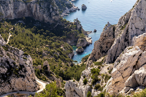 Luftaufnahme von felsigen Bergen, kurvenreicher Straße und ruhigem Seehafen in Calanques de Marseille (Massiv des Calanques), Provence, Frankreich - Foto, Bild