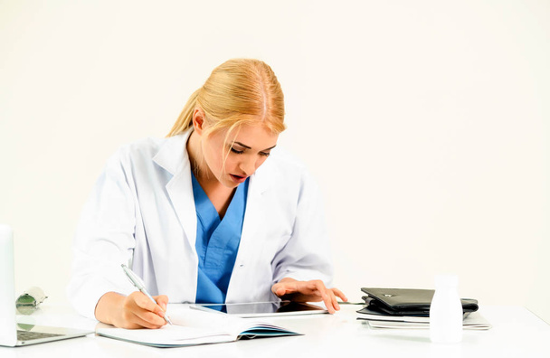 Жінка-лікар в лікарні або інституті охорони здоров'я, що працює над медичною доповіддю за офісним столом
. - Фото, зображення