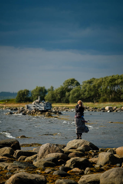 Девушка стоит в платье на берегу Белого моря
. - Фото, изображение
