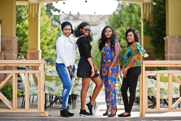 Group of four african american girls posed outdoor against city restaurant summer terrace. - Foto, Imagen