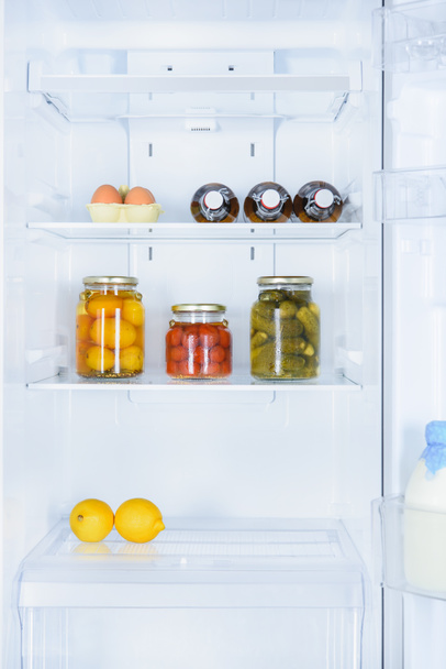 lemons, preserved vegetables and eggs in fridge - Фото, изображение