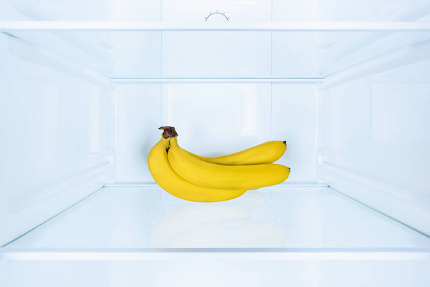 ripe tasty bananas on shelf in fridge - Photo, Image