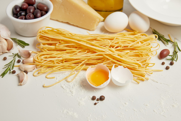  zbliżenie ułożone składniki do gotowania włoski makaron na białym stole - Zdjęcie, obraz