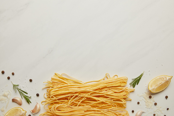 flat lat with assorted italian pasta ingredients arranged on white marble surface - Foto, imagen