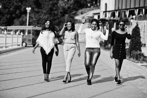 Group of four african american girls walking at city on sunny day. - Foto, Imagem