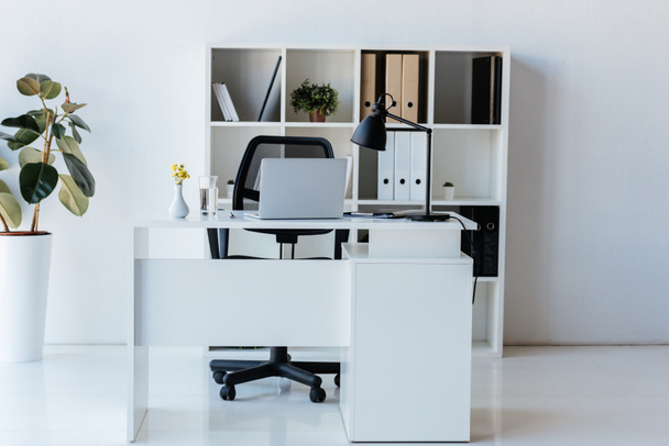 テーブル、ノート パソコンのフォルダーと棚と近代的なオフィスのインテリア - 写真・画像