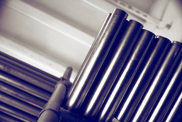 Nouveaux tuyaux métalliques, avec revêtement chromé, reposent sur des étagères de stockage. Contexte conceptuel de l'industrie métallurgique
 - Photo, image