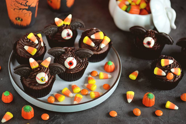 Schokoladen-Cupcakes "Fledermäuse" - leckere Backbonbons für die Feier von Halloween. - Foto, Bild
